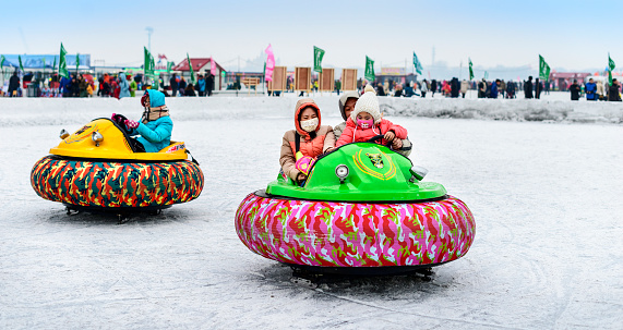 Harbin, China - January 13, 2015: People mess about on dodgems on the frozen Songhua River. Located in Harbin City, Heilongjiang Province, China.