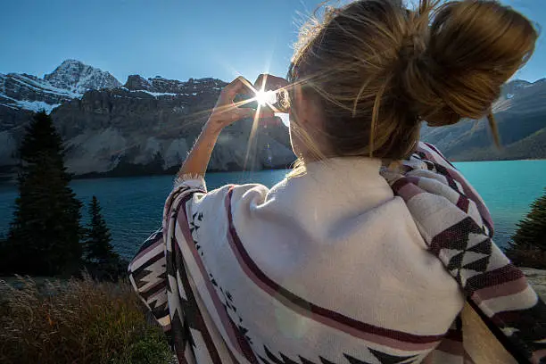 Photo of Young woman making heart to spectacular lake mountain scenery