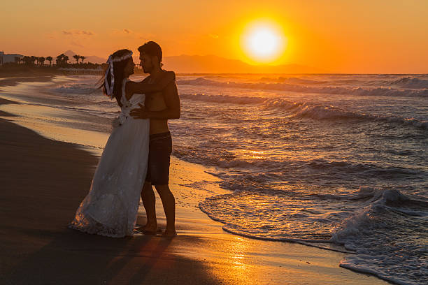 istock Just married young couple on a hazy beach at dusk 497510144