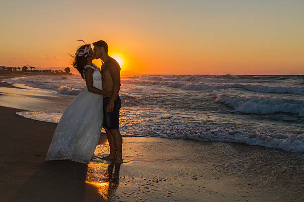 istock Just married young couple on a hazy beach at dusk 497510280