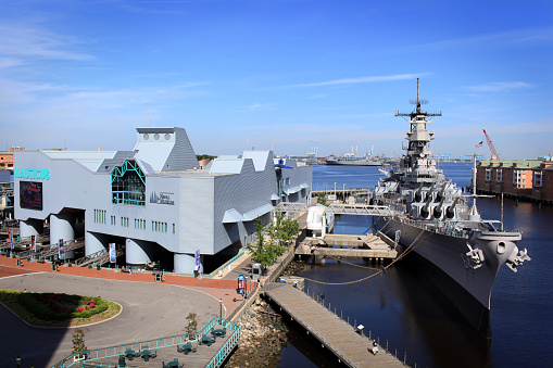 Norfolk, Va. USA  - June 7, 2014:   On a sunny morning a image of Nauticus Museum and the USS Wisconsin Naval ship which are popular attractions in Norfolk, Virginia.