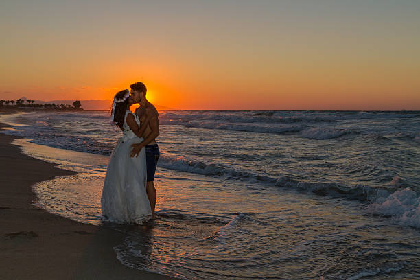 istock Just married young couple on a hazy beach at dusk 497510306