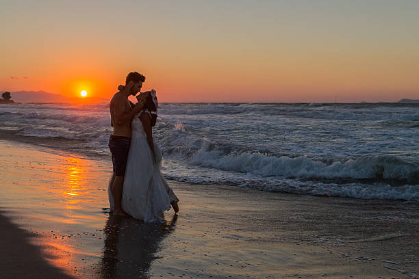 istock Just married young couple on a hazy beach at dusk 497510368