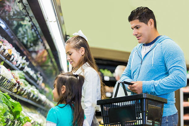 istock Father shopping with young daughters in supermarket 497511150