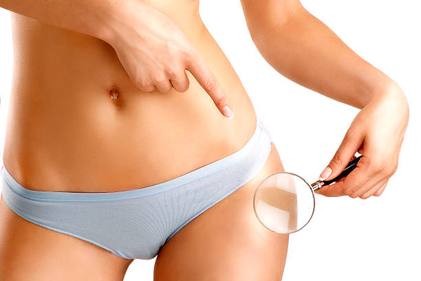 istock Woman checking her skin with a lens closeup on hips 497511277