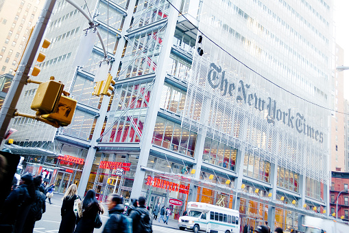 New York, USA - January 7, 2013:  Facade of the New York Times headquarters building on 8th Ave in a winter morning. The New York Times is an american daily newspaper founded in 1851. Commuters and bus on the street.