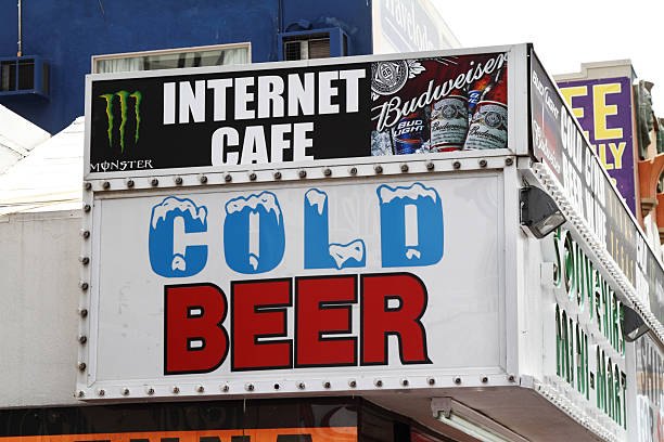 Internet cafe with cold beer. Las Vegas, USA - May 17, 2011: An Internet Cafe on the Las Vegas Strip advertises Budweiser and Monster energy drinks above a cold beer sign on the building storefront.  monster energy stock pictures, royalty-free photos & images