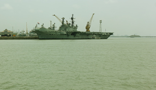 Norfolk, Virginia, USA - May 30, 2023: An American flag waves in the wind on the stern of the USS George H.W. Bush (CVN-77) aircraft supercarrier docked at Naval Station Norfolk while in port.