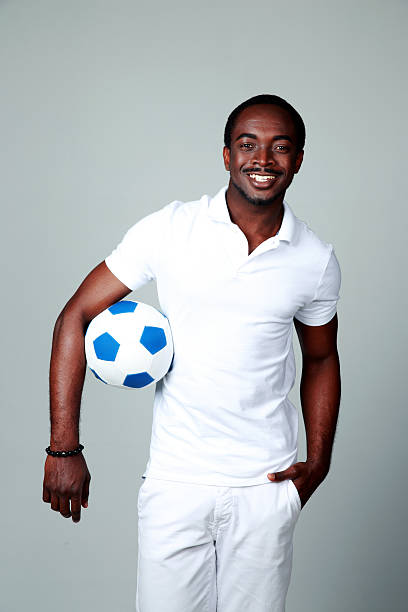 istock Smiling african man holding soccer ball 497512067