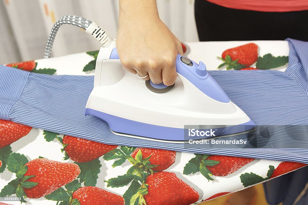 Woman's Hand Ironing sleeve On Ironing Board Activity Stock Photo