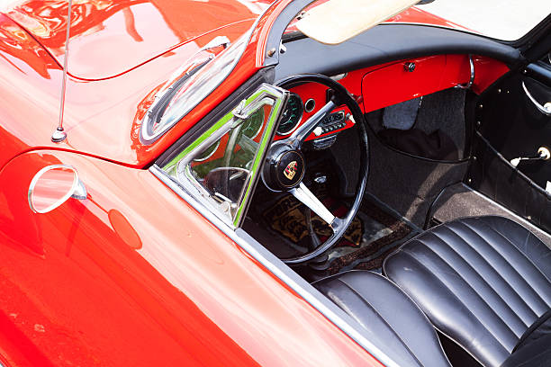 Essen, Germany - June 1, 2014: Steering wheel of oldtimer Porsche 1600, red convertible car with black seats. Car is standing on grounds of Zeche Zollverein during free, public and private oldtimer meeting in Essen.