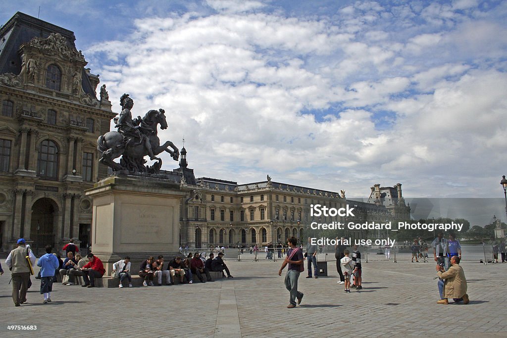France: The Louvre in Paris Paris, France - August 3, 2006: Visitors walk around the outside of the Louvre (Musée du Louvre) in central Paris. Once a palace, it is now one of the largest museums in the world with almost 35,000 objects dating from prehistory to the 21st Century. With more than 9.7 million visitors each year, the Louvre is the world's most visited museum. Art Stock Photo