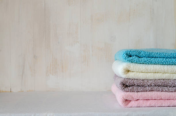 istock Stack of bath towels on light wooden background closeup 497521702