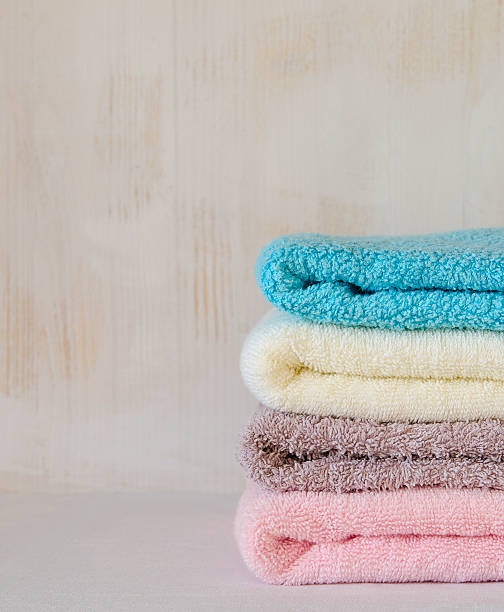 istock Stack of bath towels on light wooden background closeup 497521738
