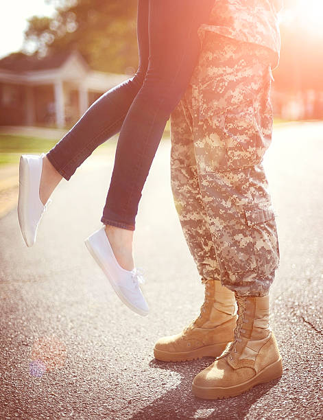 Young military couple kissing each other, homecoming concept Young military couple kissing each other, homecoming concept, warm orange toning applied military deployment photos stock pictures, royalty-free photos & images