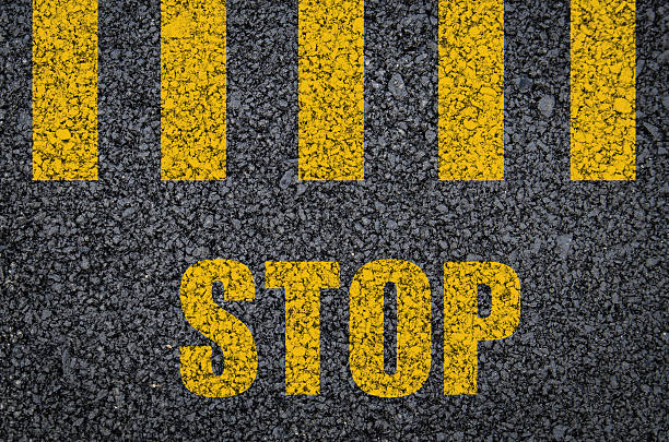 Yellow pedestrian crossing road marking with stop sign