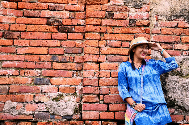 Thai woman portrait at Brick wall Background of Wat Yai chaimongkol in Ayutthaya, Thailand