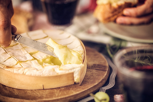 Baked Camembert cheese with garlic and rosemary. This soft, creamy and surface-ripened milk cheese is a delicious snack.