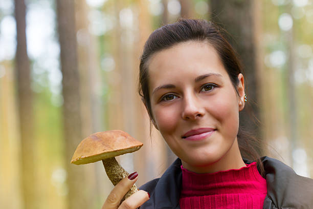 istock Woman with edible mushroom in the forest 497523152