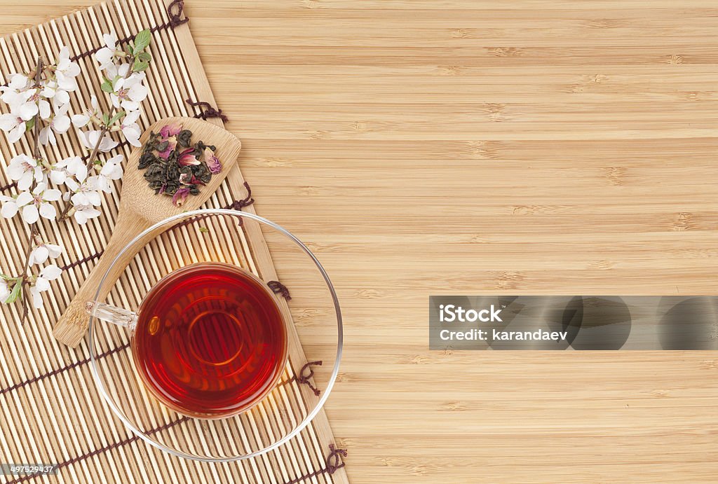 Japanese green tea and sakura branch Japanese green tea and sakura branch over mat and bamboo table with copy space Above Stock Photo