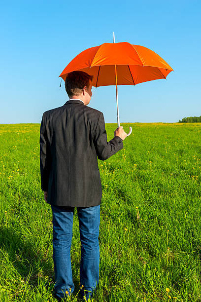 istock man in the field with orange umbrella 497529723