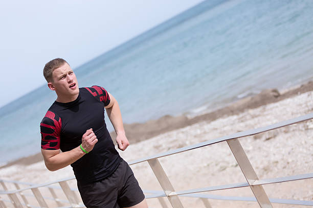 istock male runner running on the beach 497534126