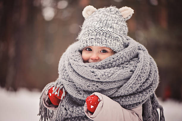 cozy outdoor portrait of happy toddler child girl in winter dreamy cozy outdoor portrait of toddler child girl in winter, wearing red gloves, grey knitted hat and scarf coat garment photos stock pictures, royalty-free photos & images