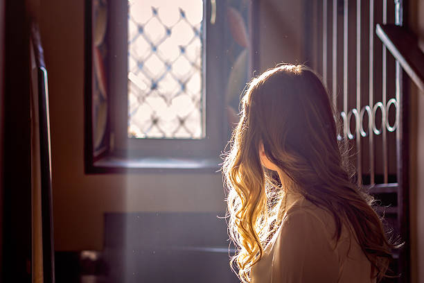 child looking out the window of the church child looking out the window of the church while the light falls on her jewish girl stock pictures, royalty-free photos & images