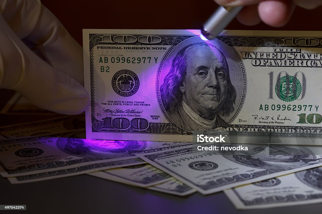 Dollar bill in uv light Dollar bill in uv light, fraud check Crime Stock Photo