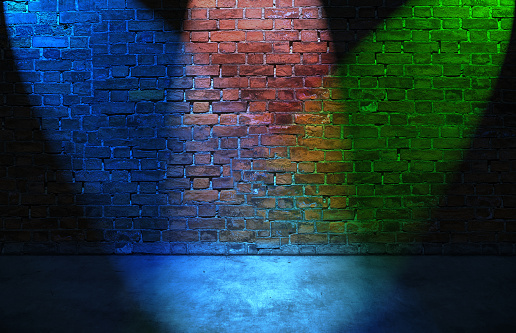 Colorful RGB spot lights on old brick wall