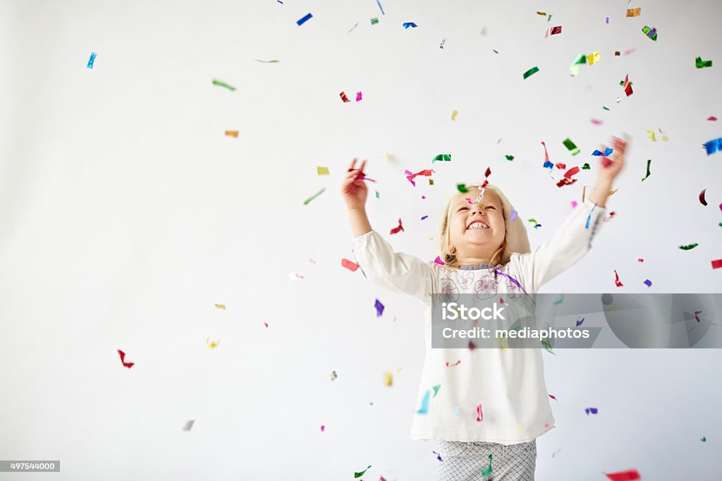 Holiday excitement Ecstatic little girl catching falling confetti Child Stock Photo