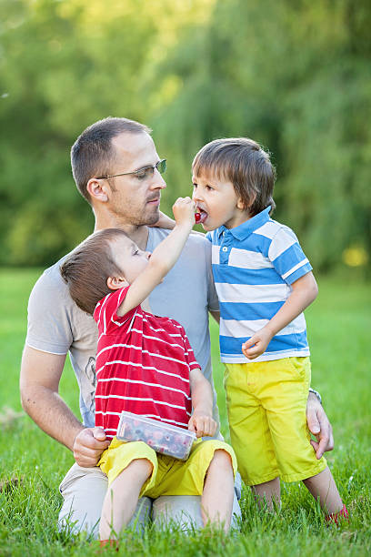istock Father with two kids, eating cherries 497545089