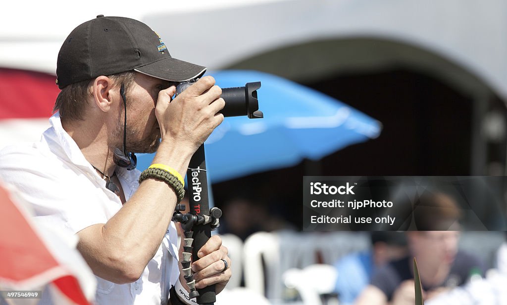 Male Photographer Abbotsford, Canada - August 11, 2012: This image shows a male photographer shooting outdoors with a small camera on a monopod. Adult Stock Photo
