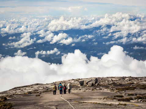 Kinabalu Park, Sabah, Malaysia - May 19, 2014: Unidentified hikers walking above the clouds at the top of Mount Kinabalu, Malaysia's highest peak, on May 19th, 2014.