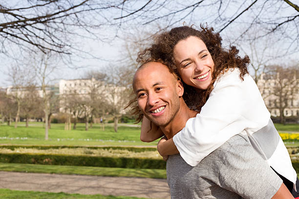 istock couple having a piggyback in the park 497548638