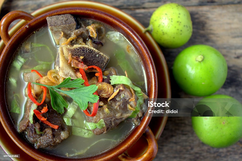 Sup Tulang - Malaysian famous soup Sup Tulang - is the Malaysian version of bone broths. It is a traditional recipe, a humble but nutritious broth eaten for generations as comfort food. garnish with cili, lime and vegetables 2015 Stock Photo