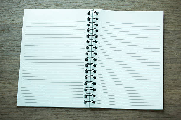 istock open spiral notebook on dark wood background 497566448