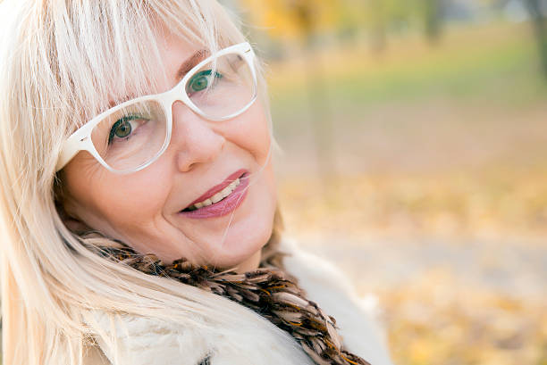 breathing autumn senior woman looking and smiling at you breathing autumn woman looking and smiling at you outside - Mature Beauty Faces Future, Women, Only Women, Happiness, Mature Women, Healthy Lifestyle, Mature Adult,  relieved face stock pictures, royalty-free photos & images