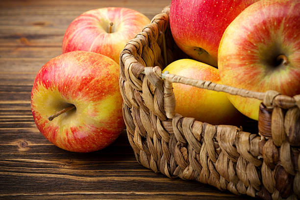 istock Fresh organic apples in basket on wooden table 497568855
