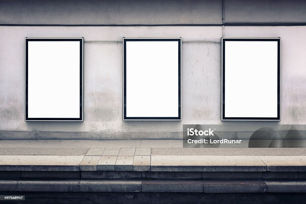 Wall advertising Three blank posters on a wall by a station platform. Includes clipping paths. Poster Stock Photo