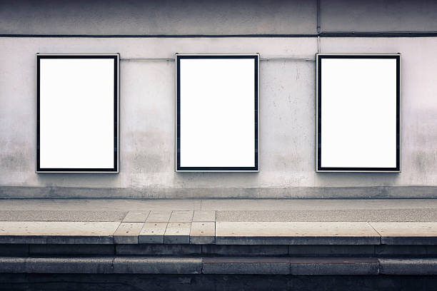 Wall advertising Three blank posters on a wall by a station platform. Includes clipping paths. railroad station platform stock pictures, royalty-free photos & images