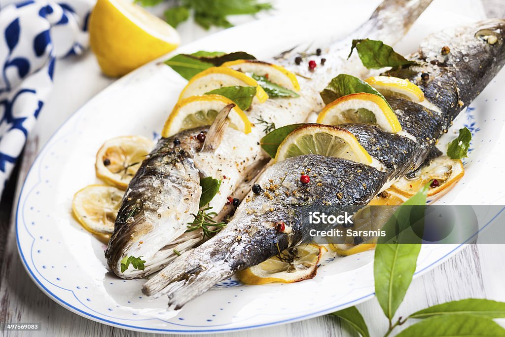 Oven-baked Sea bass Oven-baked Sea bass with lemon and herbs Baked Stock Photo