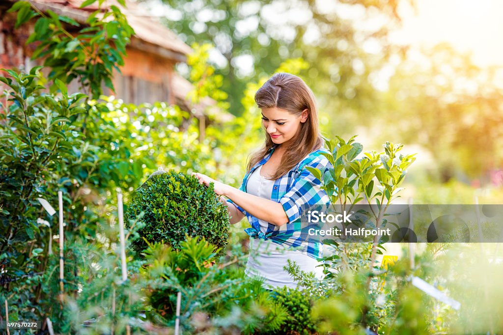 Beautiful young woman gardening Beautiful young woman gardening outside in summer nature Relaxation Stock Photo
