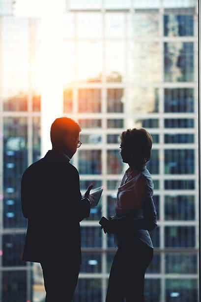 istock Man and woman standing near skyscraper window in modern interior 497575562