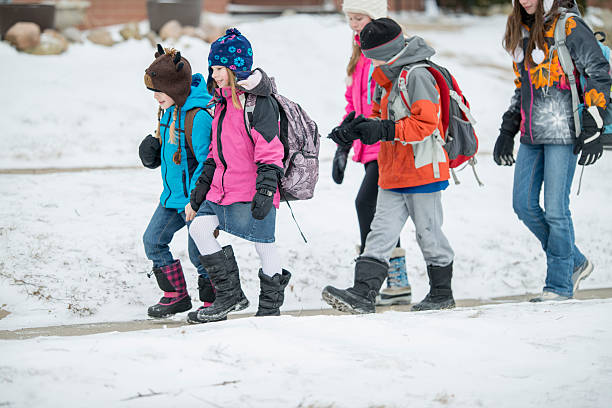 niños a pie al aire libre en invierno - bota de la nieve fotografías e imágenes de stock