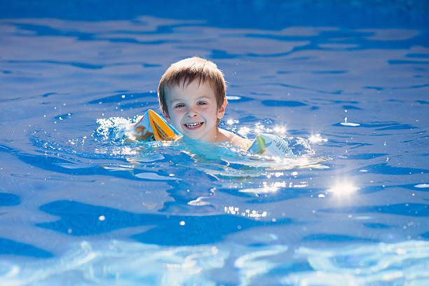 istock Cute kid in a big swimming pool 497585731