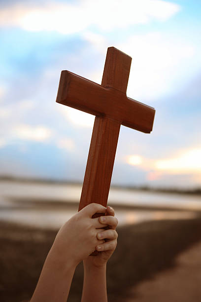 istock Child's Hands holding Cross 497585983