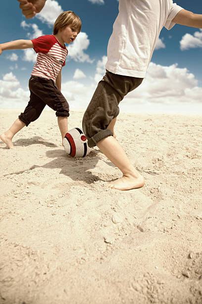 istock young children playing with ball on sandy beach 497586697