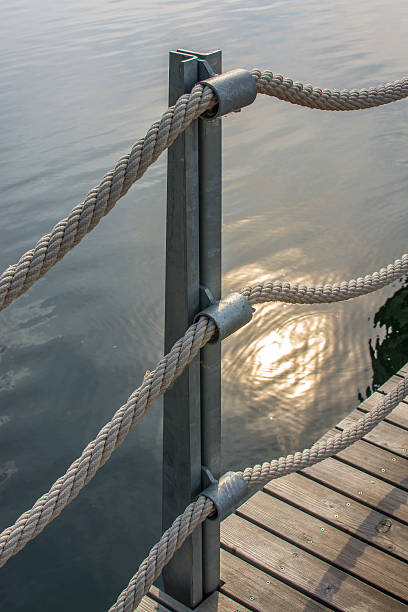 istock Banister with thick ropes over calm water 497595583