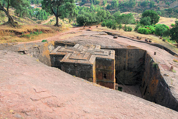 Lalibela, Ethiopia: rock-hewn Church of Saint George Lalibela, Amhara region, Ethiopia: rock-hewn Church of Saint George / Biete Giyorgis - seen from above - carved from red volcanic rock in the shape of a cross - 12th century - the most famous of the eleven monolithic churches in Lalibela - Ethiopian Orthodox Tewahedo Church - UNESCO world heritage site - photo by M.Torres the church of saint george lalibela ethiopia stock pictures, royalty-free photos & images